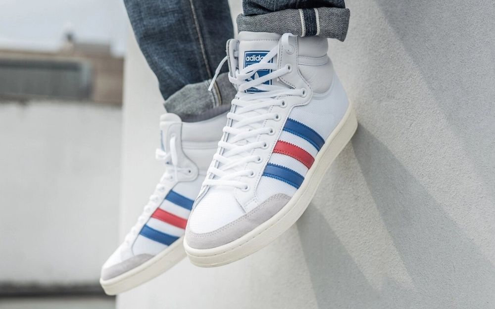 Adidas Americana hi.
Vibe années 70/80, baskets blanches aux bandes bleues et rouge.
