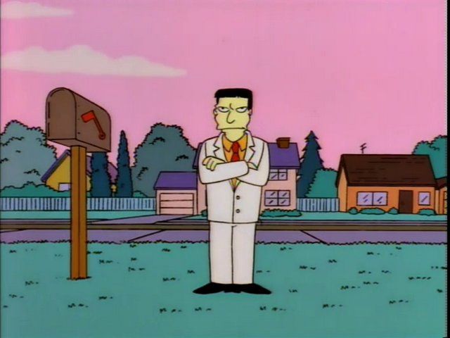 screenshot from The SImpsons: an unimpressed guy in a white suit stands with his arms crossed on the Simpson's front lawn