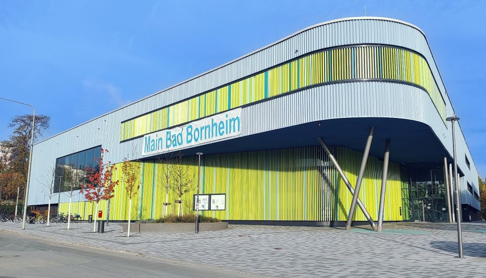 Aufnahme des Main bad bornheim aus der Froschperspektive. Davor ein freier Platz überraschenderweise ohne Autos