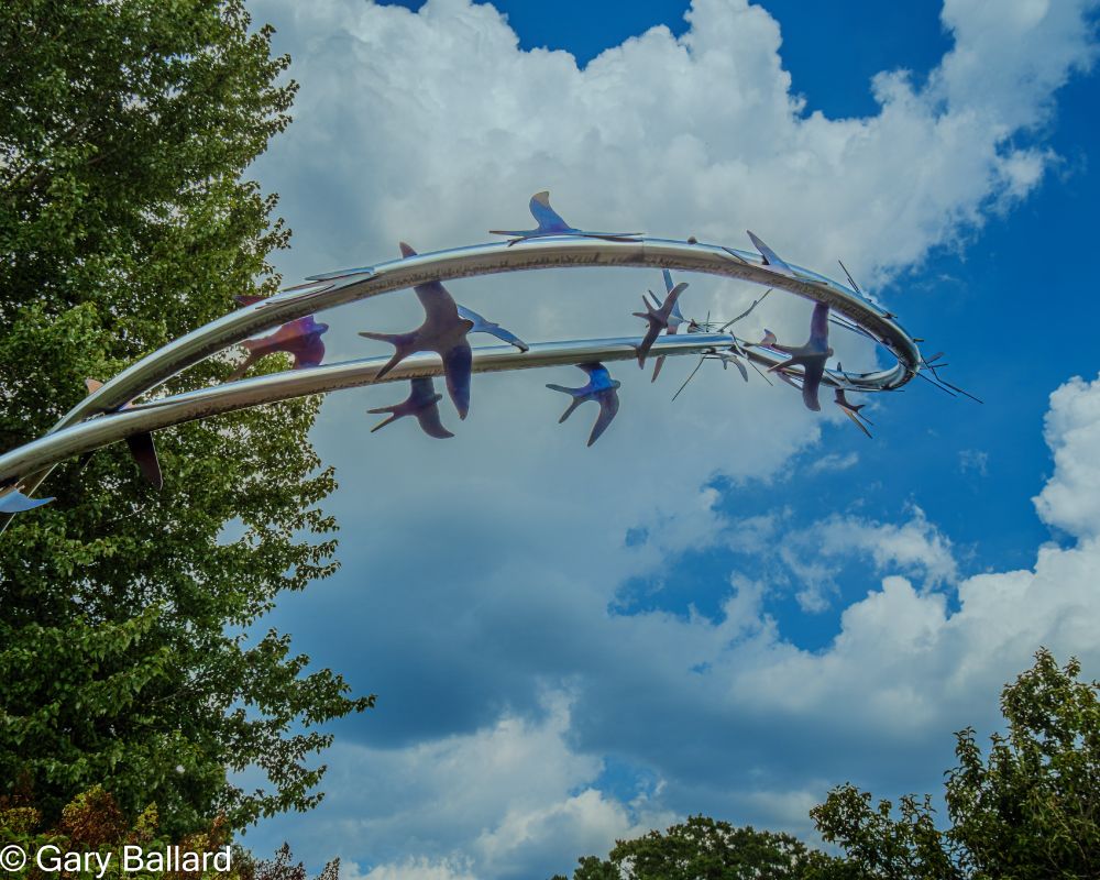 A bird sculpture set against the blue sky at the Memphis Botanic Garden.