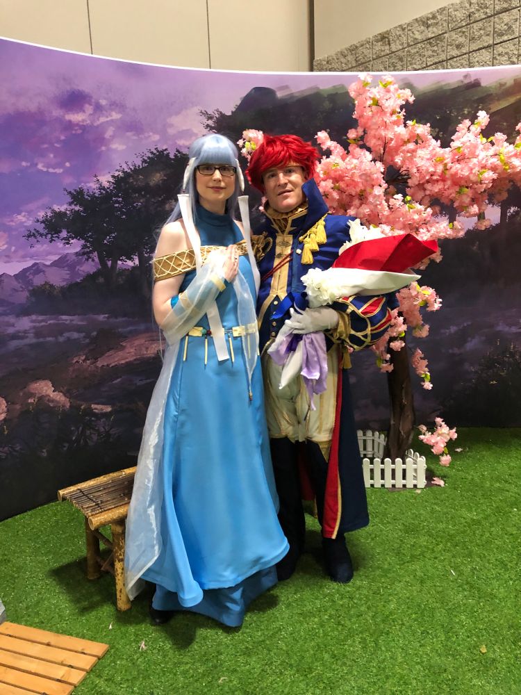 The same two people cosplaying Eliwood and Ninian, standing next to each other.