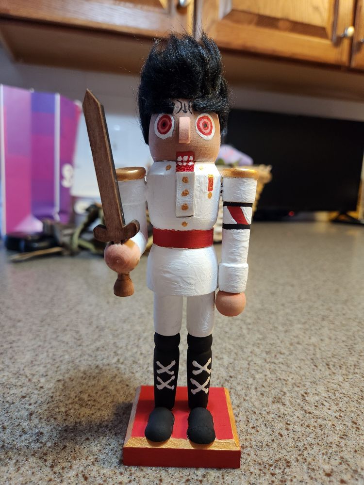 A photograph of a nutcracker doll holding a sword painted to look like Kiyotaka Ishimaru from Danganronpa.