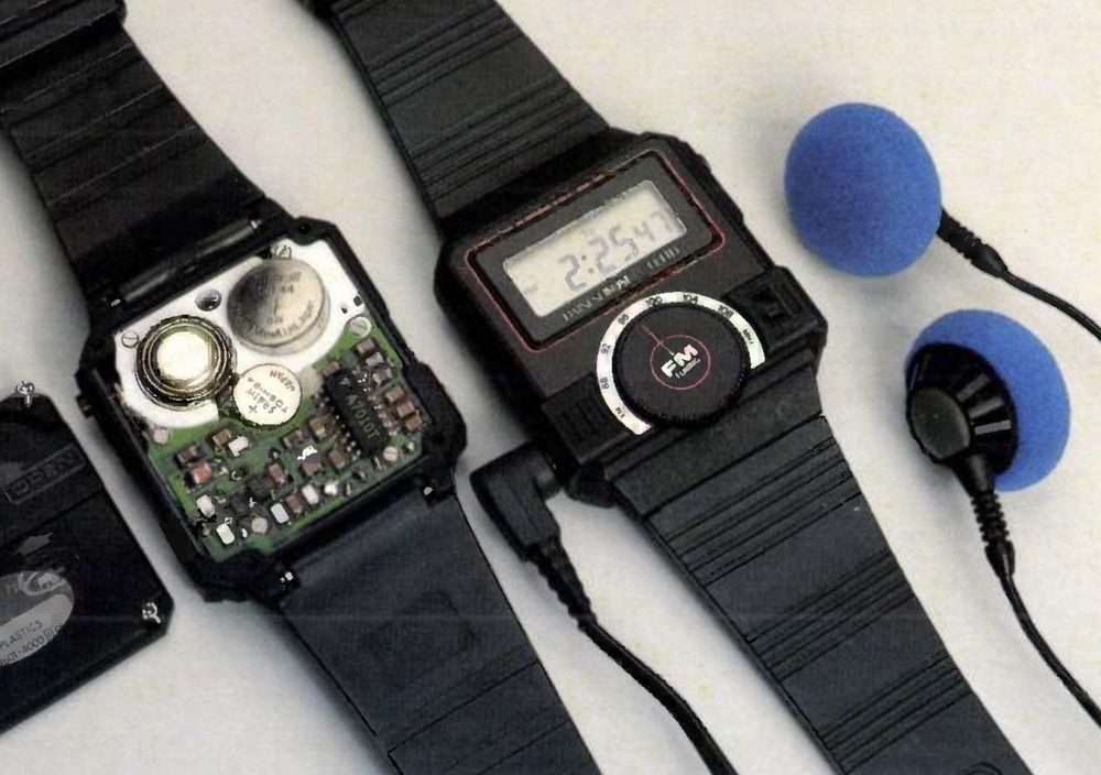 A photo of a digital watch with a tuning knob on the front and earbud headphones plugged into the side. Next to it is the wristwatch with the back removed, revealing the batteries inside, along with tiny surface-mount components and a small black integrated circuit.