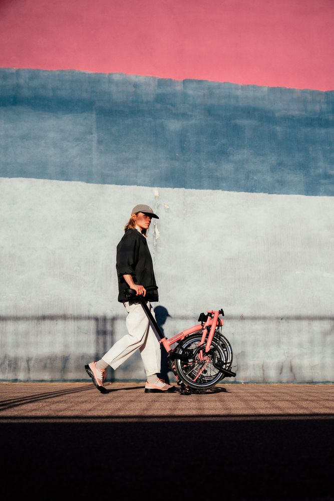 a person pushing a C Line Brompton bike