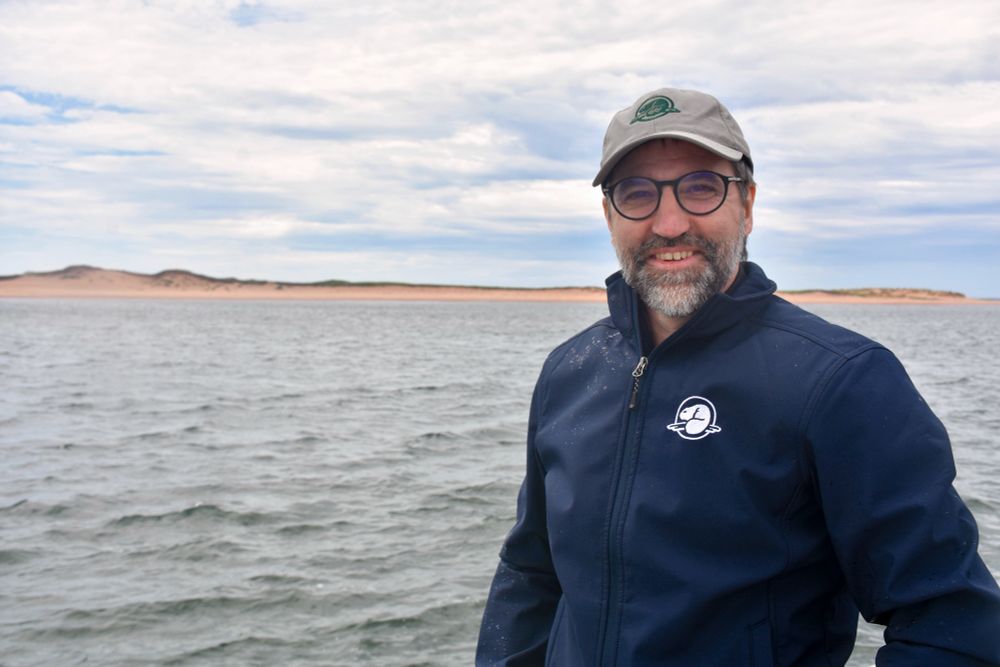 Le Ministre Guilbeault sourit pour une photo. Une étendue d’eau est en arrière-plan.