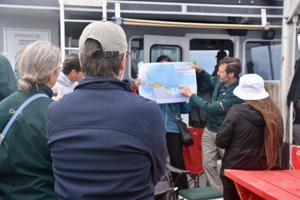 Le Ministre Guilbeault (de dos) regarde la carte du nouveau parc national.