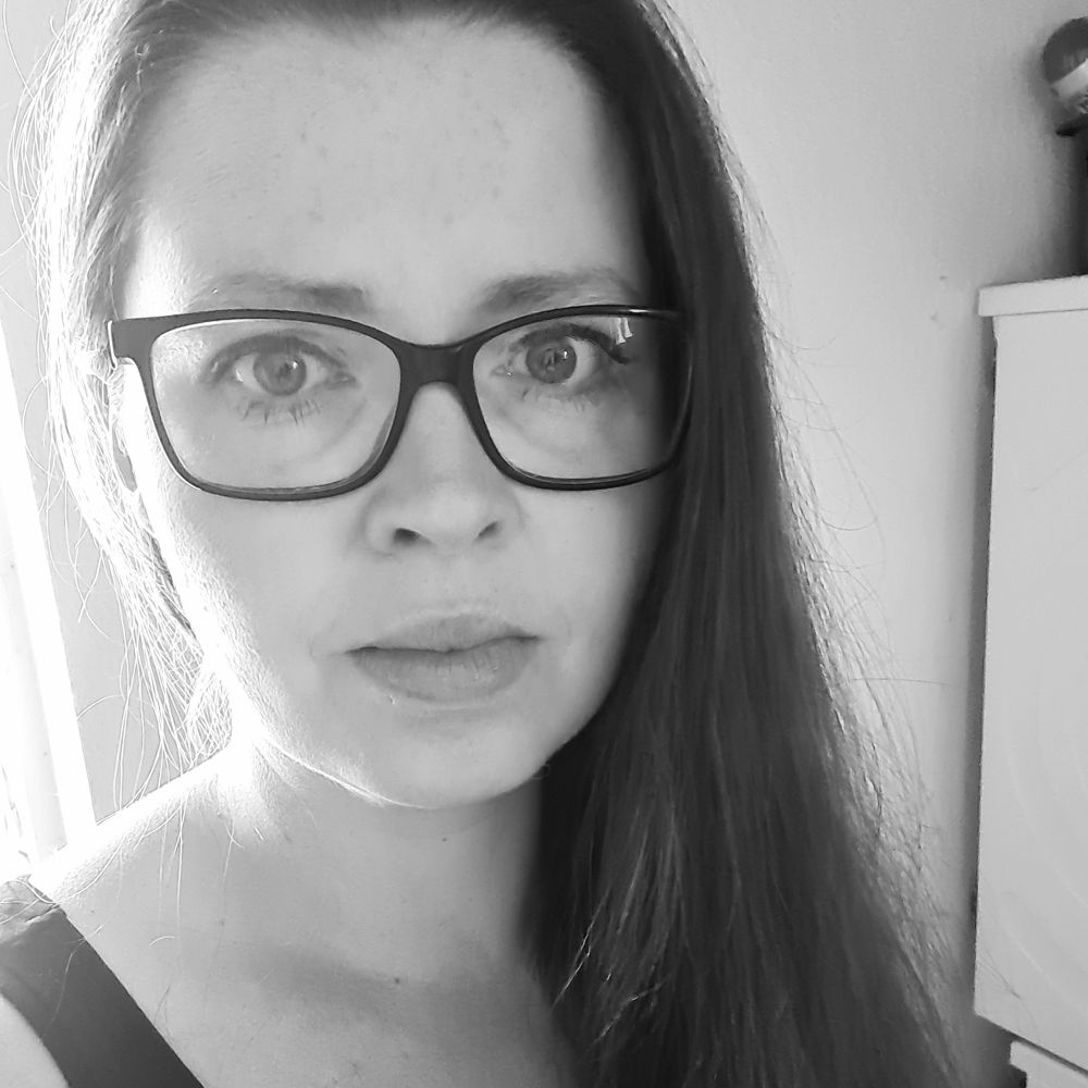 Selfie einer dunkelhaarigen Frau mit schwarzer, eckiger Brille.