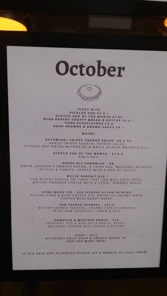 A photograph of a menu

October

PICKY BITS:

PICKLED EGG £1.5 V

SCOTCH EGG OF THE MONTH £7.50

BEAR BAKERY CRUSTY BREAD & BUTTER £3.5V

PORK SCRATCHINGS E3.5

HASH BROWNS & BROWN SAUCE £5 V

MAINS:

AUTUMINAL CRISPY SQUASH SALAD -£8.5 VE

BAKED CRISPY SQUASH, POTATO SALAD, PICKLES, RED ONION, MAYONAISE & MAPLE GLAZED WALNUTS, DILL.

SCOTCH EGG OF THE MONTH £7.5 V

ASK STAFF

HOUSE BLT SANDWICH £8

DAVID JOINSON'S SMOKED BACON, A FRIED EGG, MUSTARD, KETCHUP, LETTUCE & TOMATO. SERVED WITH A BAG OF CRISPS.

WELSH RAREBIT-E10 V

THE NICEST CHEESE ON TOAST THAT YOU WILL EVER TASTE.

MATURE CHEDDAR CHEESE WITH A STOUT, RAREBIT SAUCE,

HOME-MADE PIE £16 (PLEASE ALLOW 10 MINS)

PULLED PORK & BLUE CHEESE PIE, ONTOP OF CREAMY MASH TOPPED WITH GRAVY GRAVY

PAN SEARED SEABASS £13.5

BUTTER SEARED SEABASS, CREAMY LEEK & CABBAGE FRIED NEW POTATOES, LEMON & DILL

HAMHOCK & MUSTARD BROTH 114

SEASONAL VEG & HAM-HOCK BROTH, HONEY, MUSTARD, SERVED WITH BREAD & BUTTER

SOUP £6.5

KITCHEN'S DAILY SOUP & CRUSTY BREAD VE

(ASK FOR MORE INFO)

IF YOU HAVE ANY ALLERGIES PLEASE LET A MEMBER OF STAFF KNOW. 