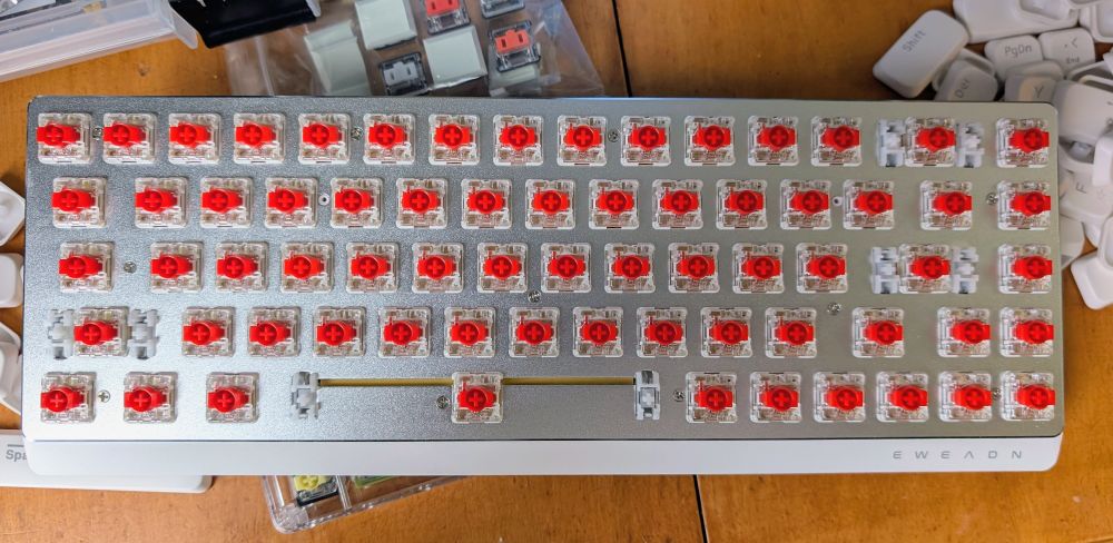 Keycaps removed top view of keyboard. A metal plate sits between keys and PCB, with an airgap