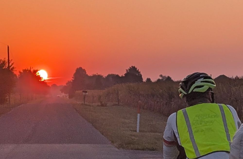 Cyclist riding into the rising sun
