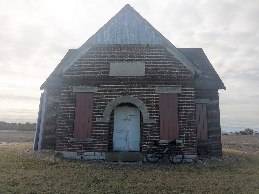 Bike leaning against a one room schoolhouse converted to barn