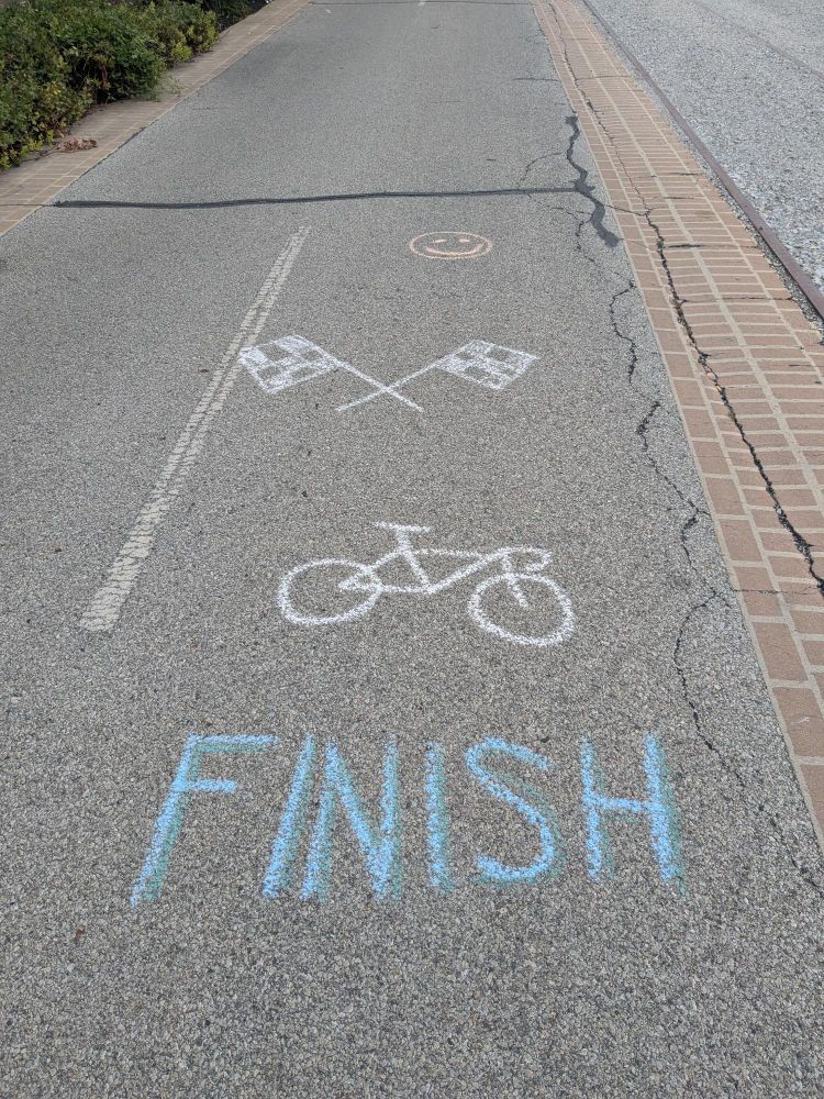 A finish line with art chalked onto a trail.