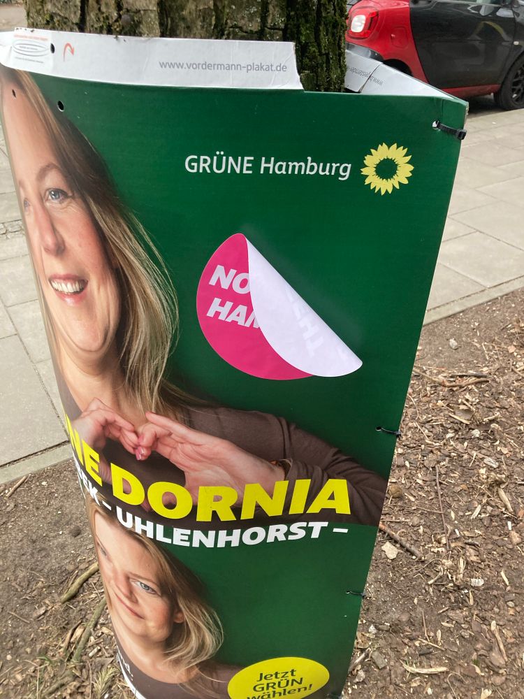 Aufkleber klebt schlecht auf Wahlplakat. 