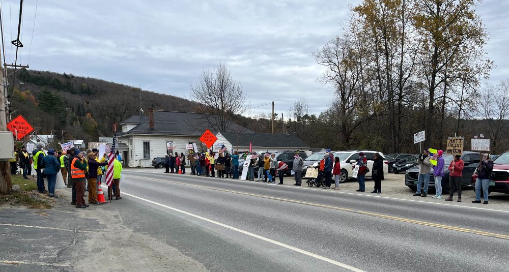 People lined up with signs at No Kings rally in Wolcott, VT.
