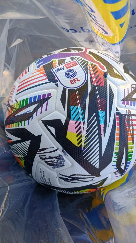 Photo of the official match ball, with EFL logo and rainbow colours, and player signatures