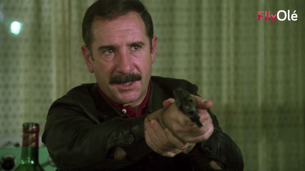 Germán Areta holding a gun while sitting at a diner