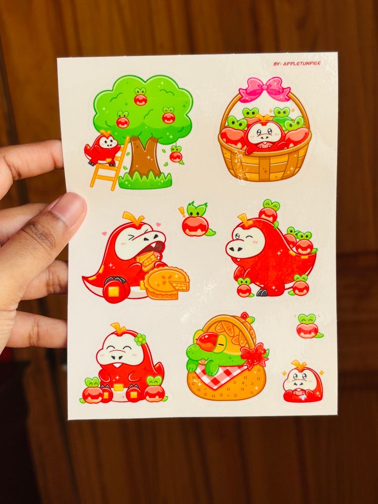 Photo of my fuecoco and applin sticker sheet! It includes stickers of fuecoco with applins, and even an Appletun in a basket