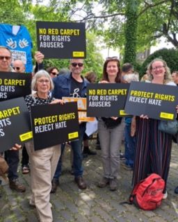 Amnesty supporters with placards reading: no red carpet for hate