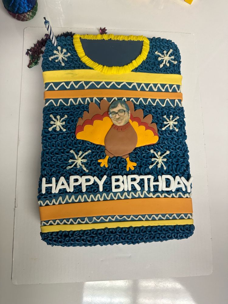 A birthday cake in the shape of a beautiful sweater with my face on a turkey too