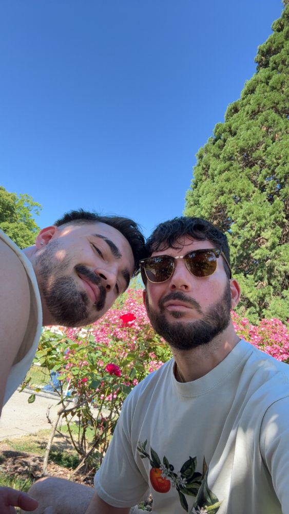 Two brunette bearded men selfie in rose garden