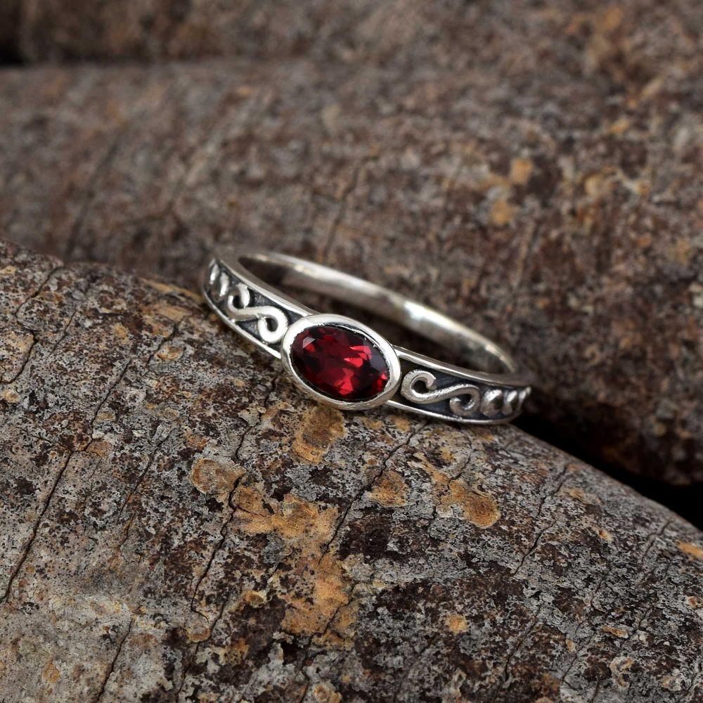 A handcrafted ring featuring a deep red garnet gemstone set in polished 925 sterling silver. The vivid stone contrasts beautifully with the silver, giving the ring a bold, elegant look with symbolic depth.