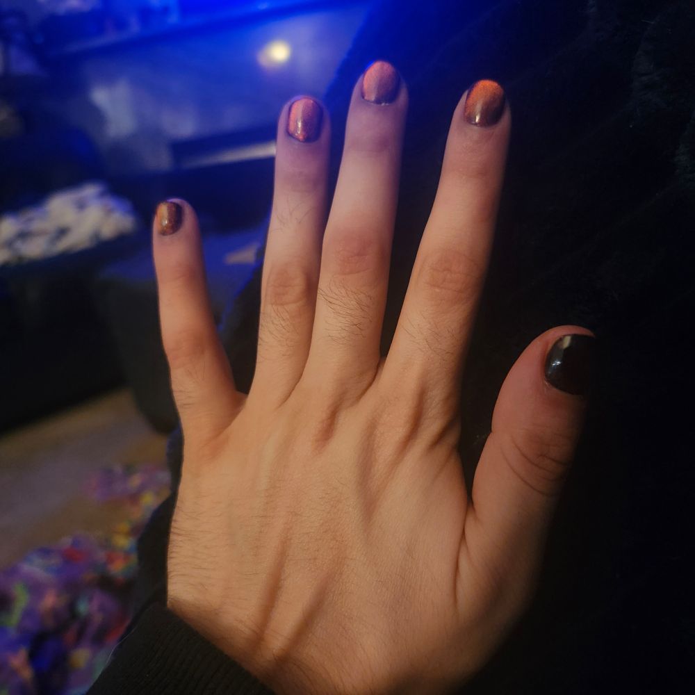 Rue showing off his new nail polish, a cat's eye orange 