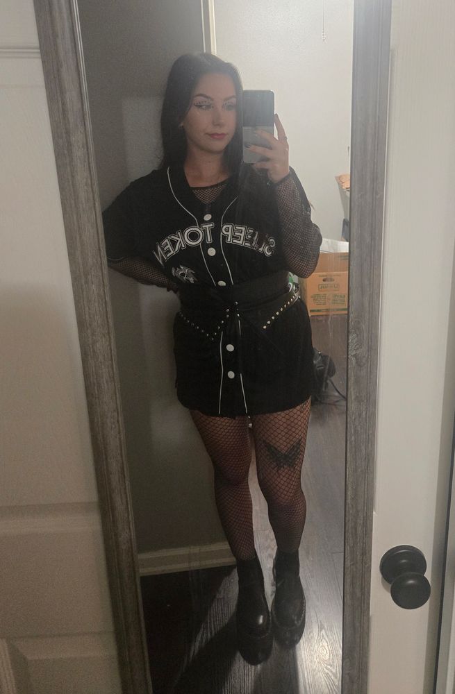 Wearing a sleep token baseball t with fishnets and docs