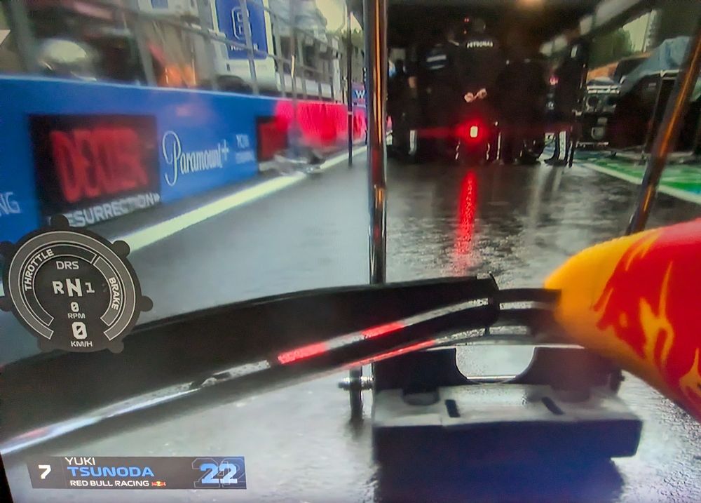 View from Yuki's car in pit lane featuring a large Dexter ad