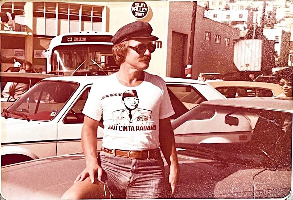 Benedict Anderson standing next to a car in 1970s Jakarta looking very zaddy like