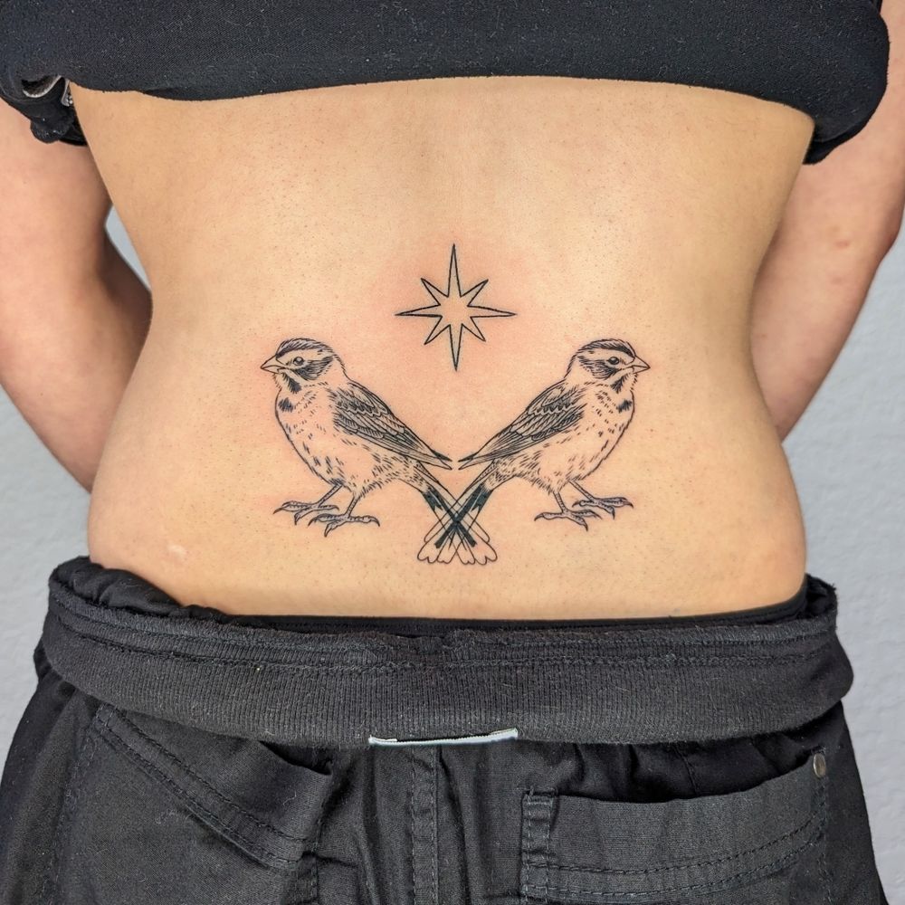 a tattoo of two lark sparrows with tails overlapping and an eight pointed star above
