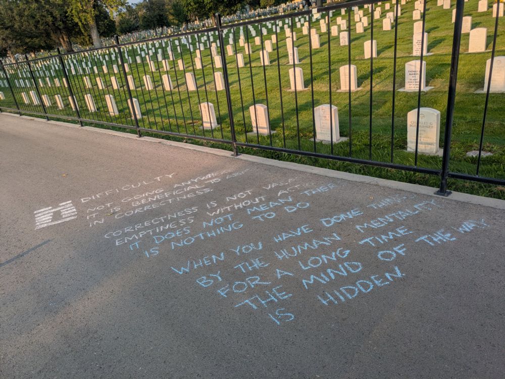 Written in chalk on a sidewalk, the I Ching hexagram Difficulty (water over thunder), and the following accompanying text:

Not going anywhere it is beneficial to abide in correctness
Correctness is not vacant emptiness without action it does not mean there is nothing to do
When you have done things by the human mentality for a long time the mind of the Way is hidden

Some of the chalk text has apparently been washed away by the sprinklers in the cemetery next to the sidewalk. In the background, behind the cemetery fence, stand rows upon rows of white veteran headstones.
