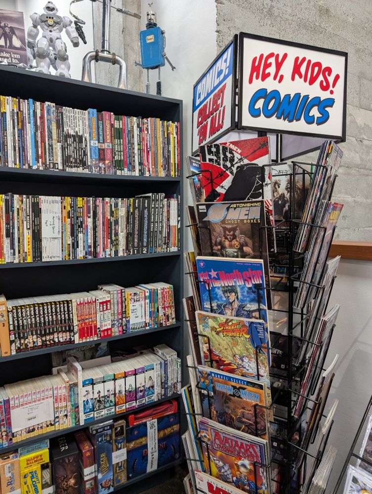 Key kids! Comics! Exclaims a spinner rack full of floppy comics.
