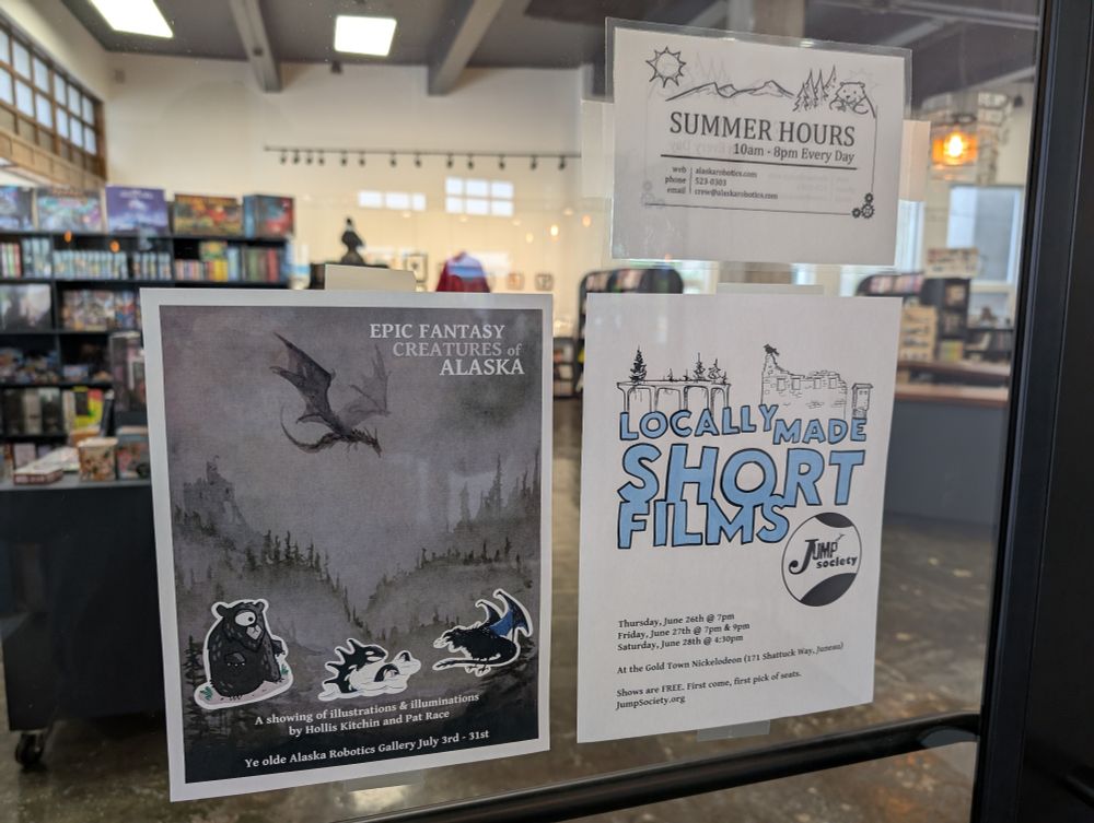 Posters hanging in gallery window for film festival and gallery show.