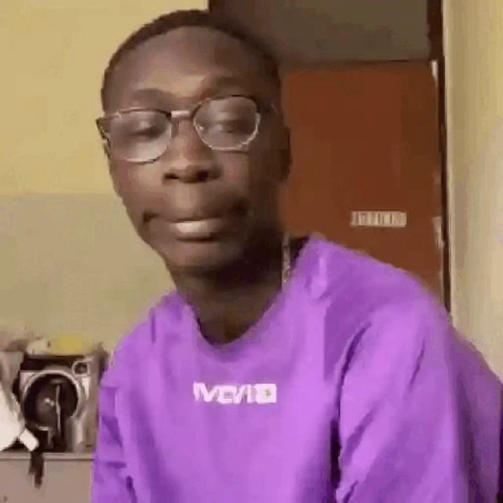 a man wearing glasses and a purple shirt is making a face .