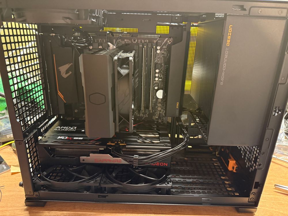 A photo of a computer with no side panel. Black case, black cpu cooler, AMD Radeon GPU