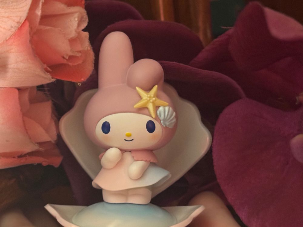 A small figure of my melody as Botticelli’s birth of Venus in front of roses and orchids