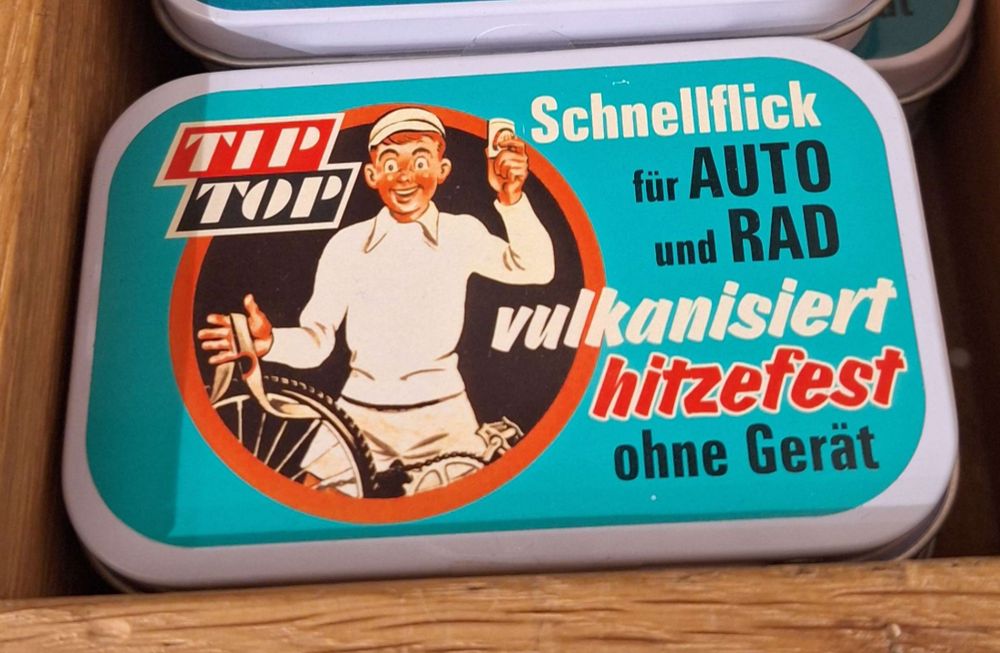 Eine Dose mit Fahrradflickzeug im Retro-Design und der Aufschrift "Schnellflick für Auto und Rad"