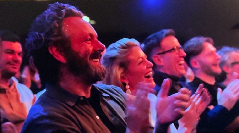 Michael in the audience in a brown jacket and black t shirt in the audience