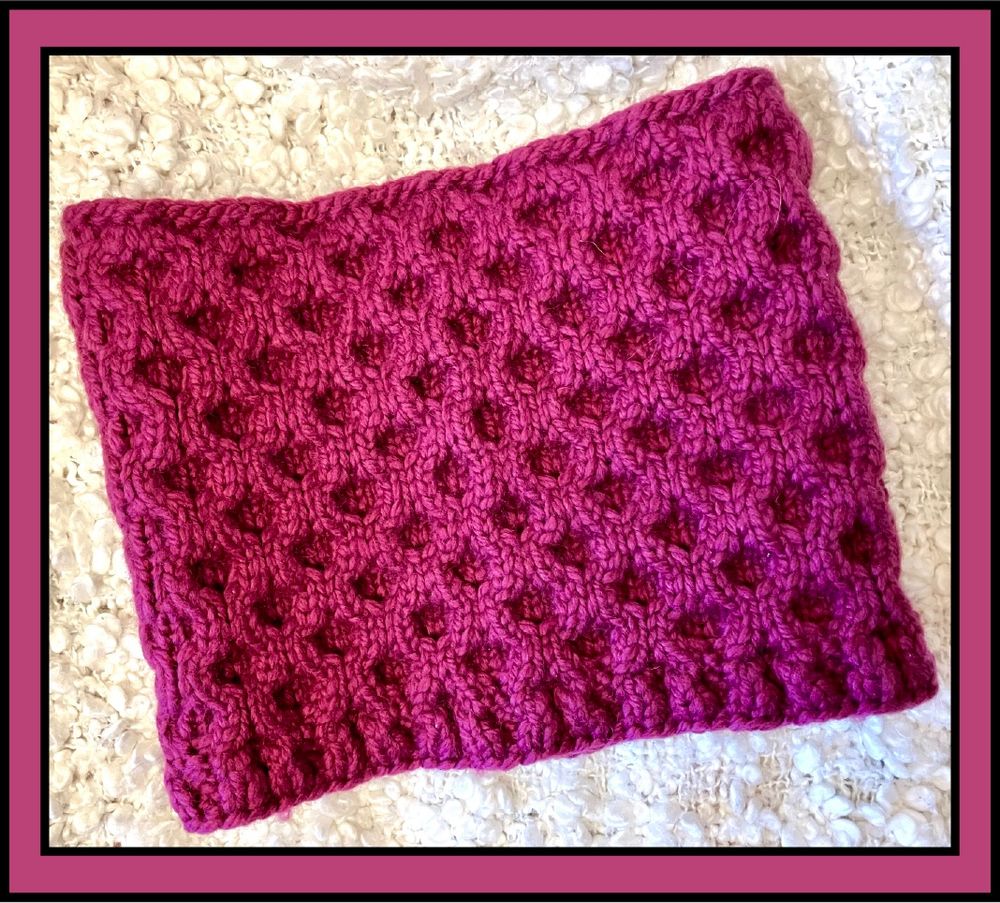 A maroon honeycomb cabled cowl photographed on a white background