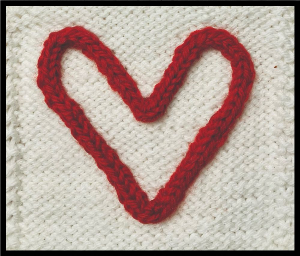 A red knitted heart on a white background