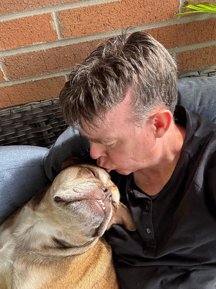 Man kissing Bulldog