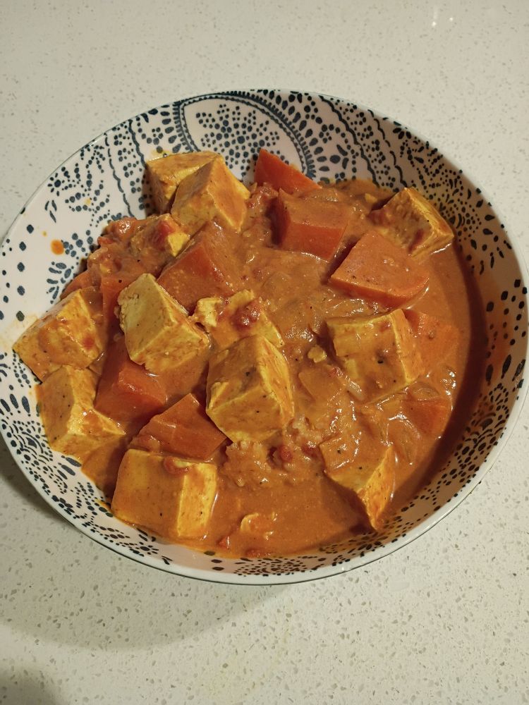 A bowl of tofu and sweet potato curry.
