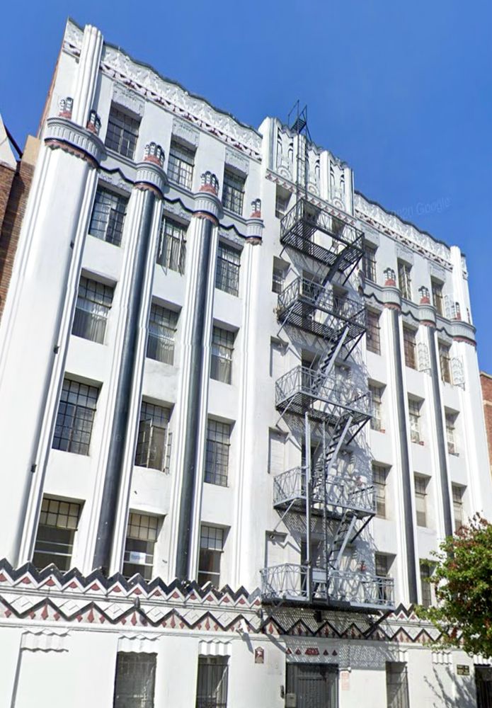 White intricately-detailed zigzag apartment with painted details in blue purple and red