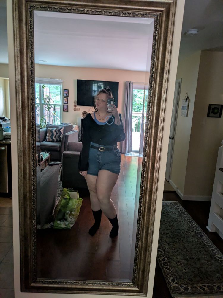 its me. i am wearing a blue bra under a black long sleeve shirt, blue jean shorts, a fake gucci belt, black compression socks and glasses