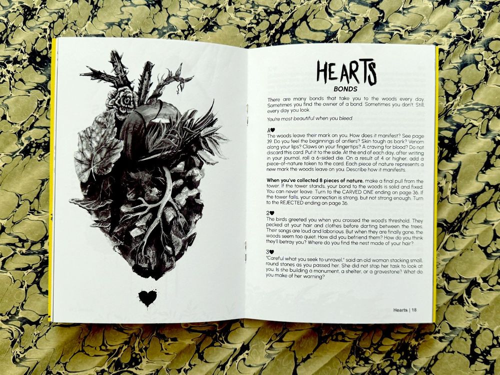 An interior example from Carved by the Garden. On the lefthand page, an illustration of a human heart made out of leaves, sticks, plants, and roots. On the righthand page, the beginning of the Hearts card prompts. Hearts are "bonds." The page features prompts for the Ace of Hearts, the 2 of Hearts, and the 3 of Hearts