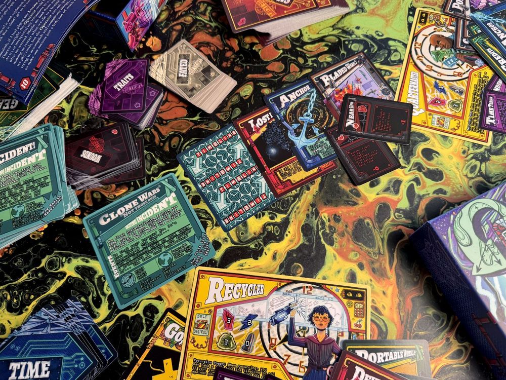 An example spread of cards that make up Zoetrope: character cards like "Recycler" and "Quartermaster." Event cards like "Clone Wars (not those ones)" as well as stacks of cards of weapons, tools, traits, wounds, and fated
