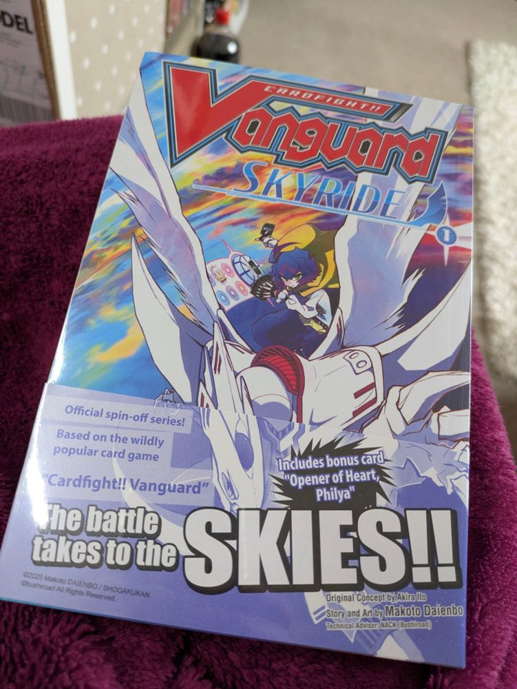 Volume 1 manga Cardfight Vanguard Skyride with free promo card. A blue haired character is riding on a white dragon on the cover