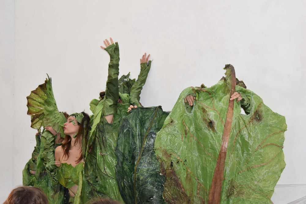3-4 people dressed in photorealistic slightly off salad costumes