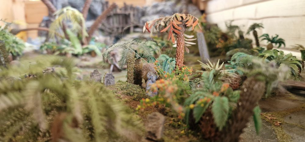 several damaged palm trees and cycads made from resin, etched brass and lasercut paper.