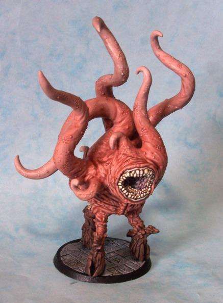 A pink, many-tentacled horror on three legs with a centrally placed circular mouth full of teeth.